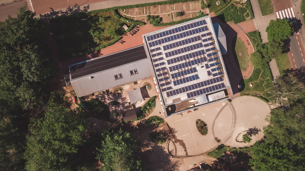 an aerial view of a building with solar panels on the roof