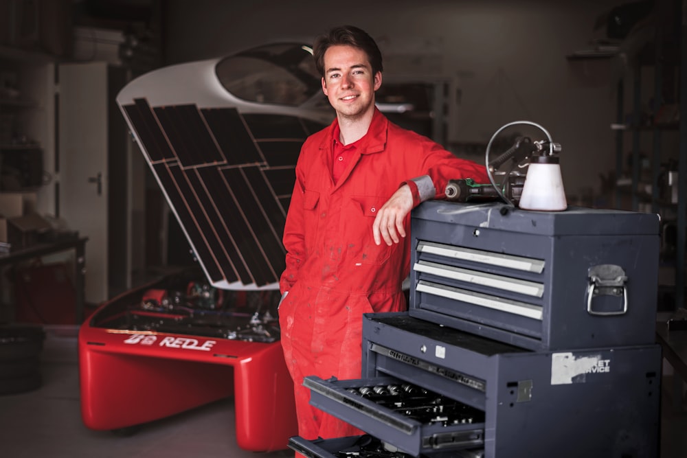 a man standing next to a toolbox in a garage
