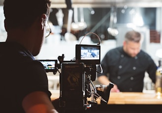 a camera set up in front of a man in a black shirt