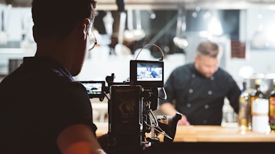 a camera set up in front of a man in a black shirt