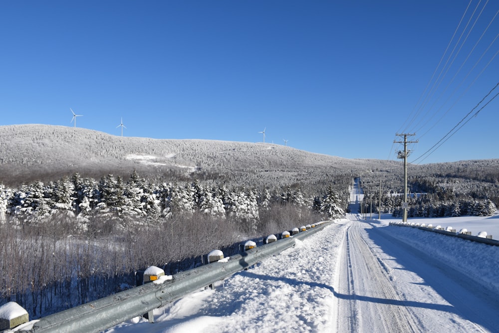 a snow covered road with power lines in the distance