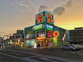 A neon-lit karaoke building with vibrant signs is seen during sunset. The signs display Japanese characters and words like 'Karaoke' and 'Open 24h'. The structure is surrounded by parked cars and people walking by, with a background of other buildings and a clear evening sky.