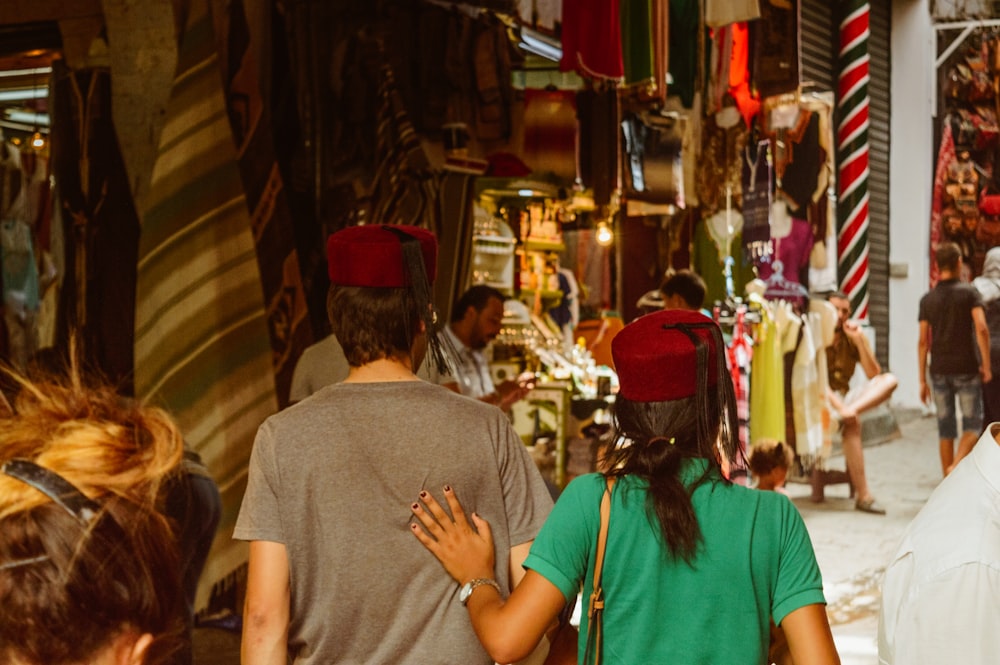 a group of people walking down a street next to shops