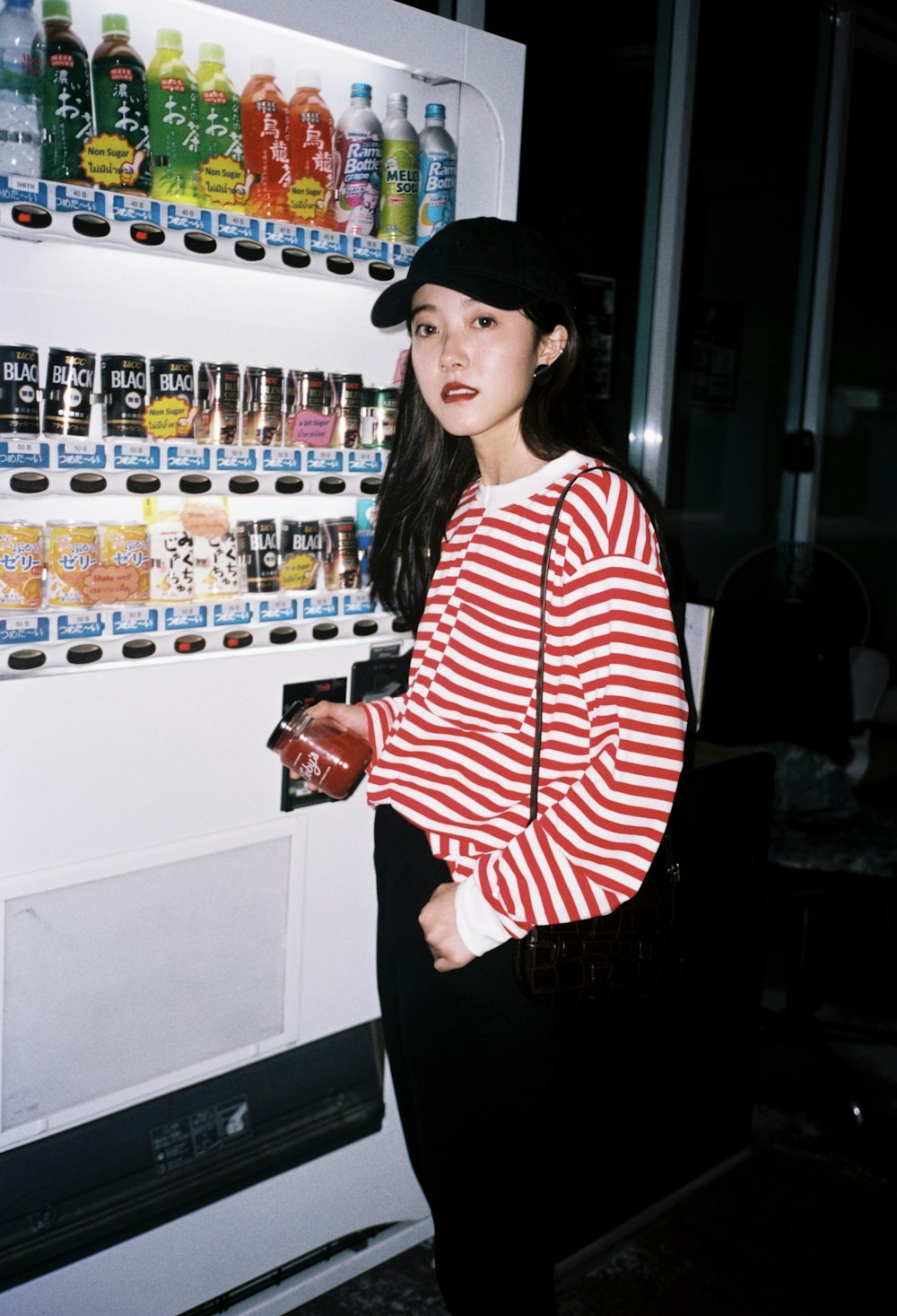 a woman standing in front of a vending machine