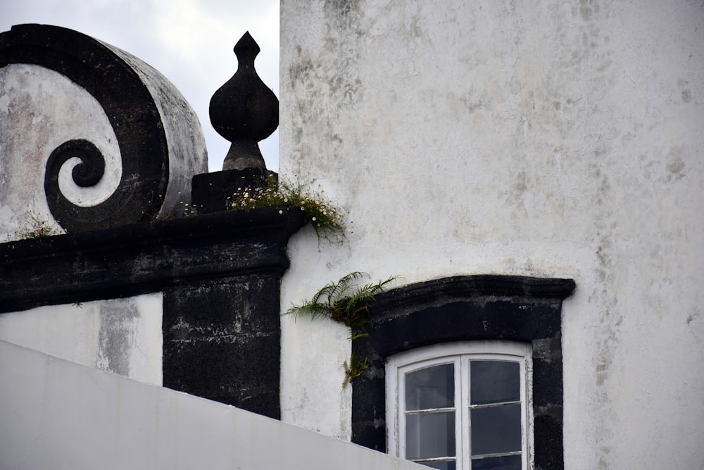 um edifício preto e branco com uma janela e uma varanda