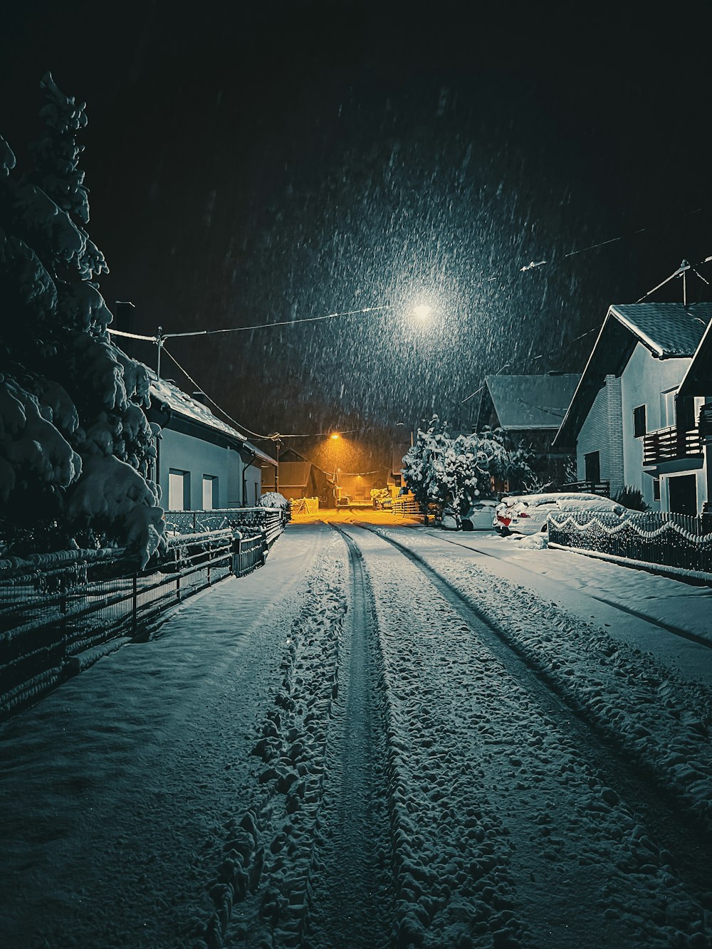 a snow covered street at night with a street light