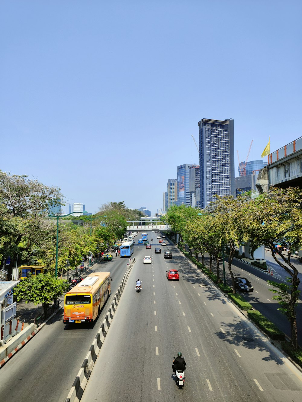 a city street filled with lots of traffic next to tall buildings