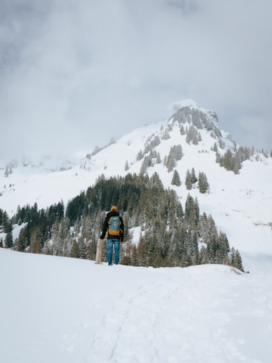 a man walking across a snow covered slope