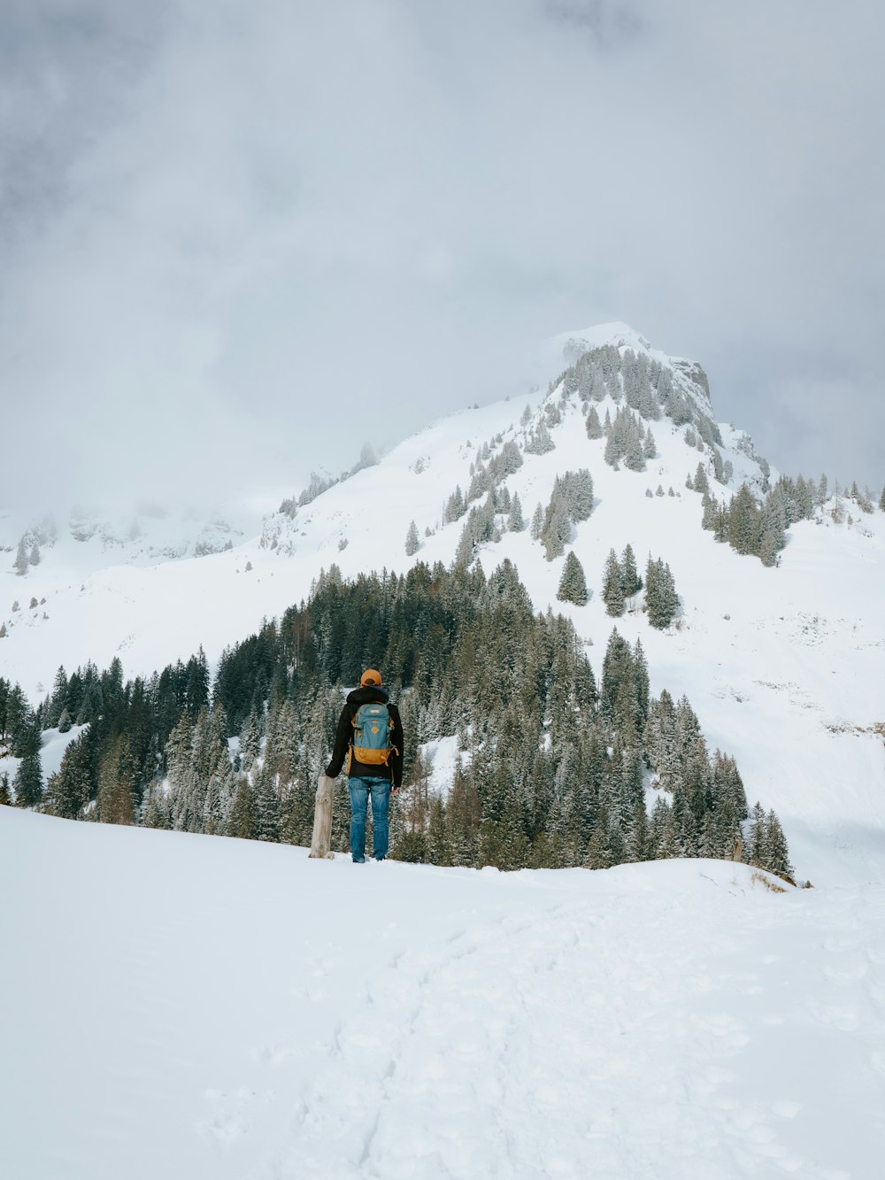 a man walking across a snow covered slope