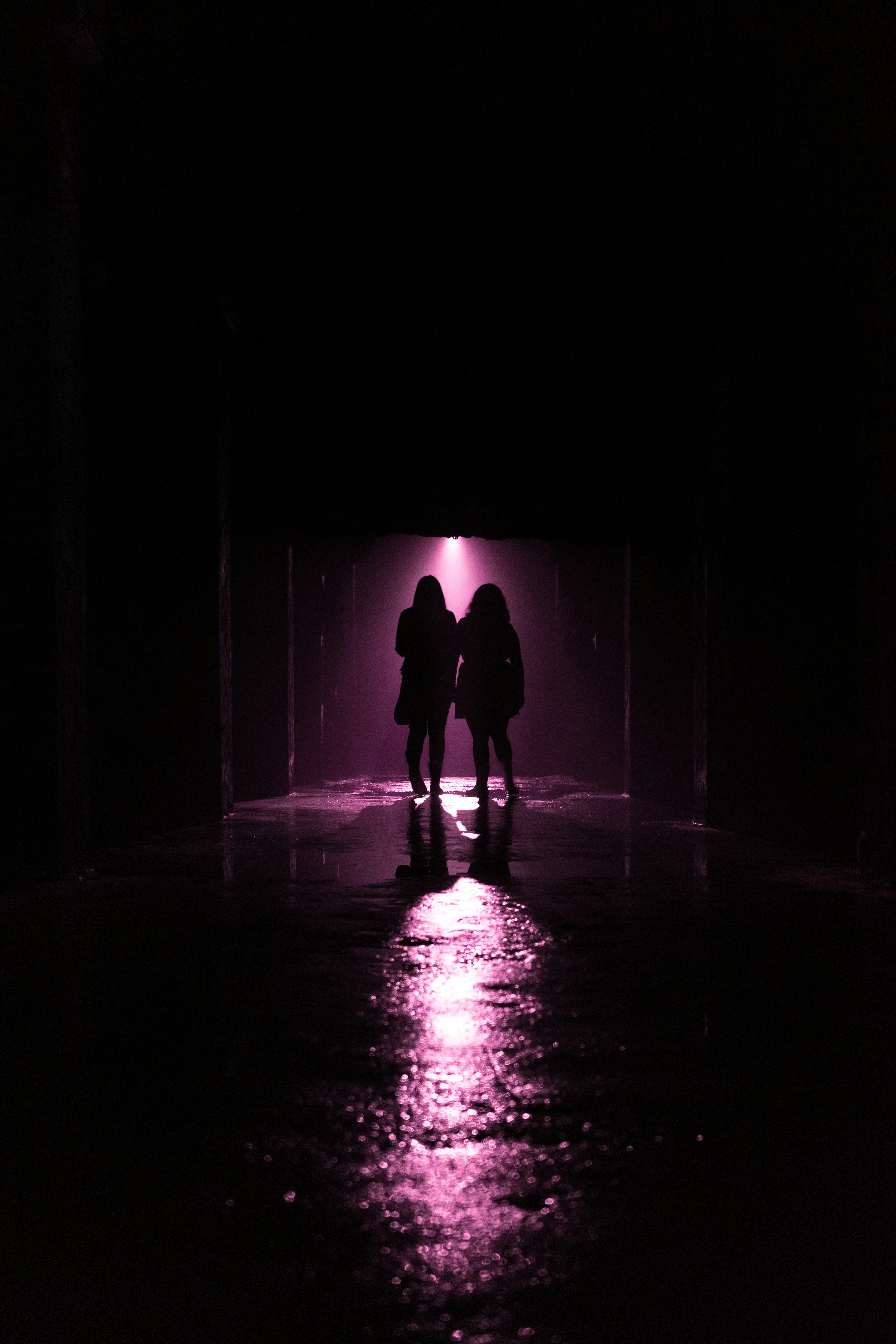a couple of people standing in a dark tunnel