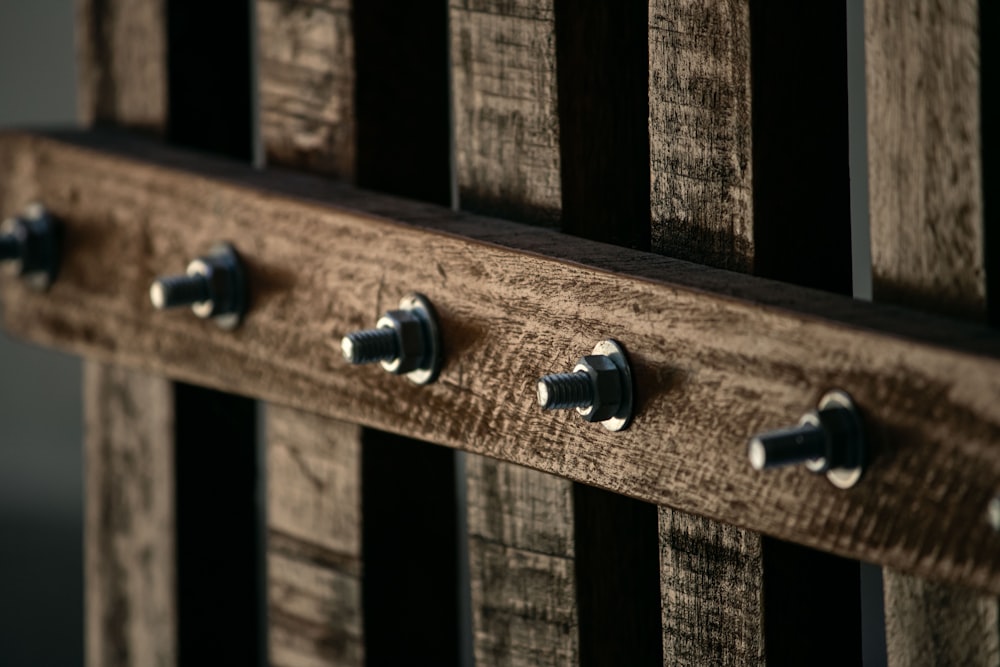 a close up of a wooden fence with metal rivets
