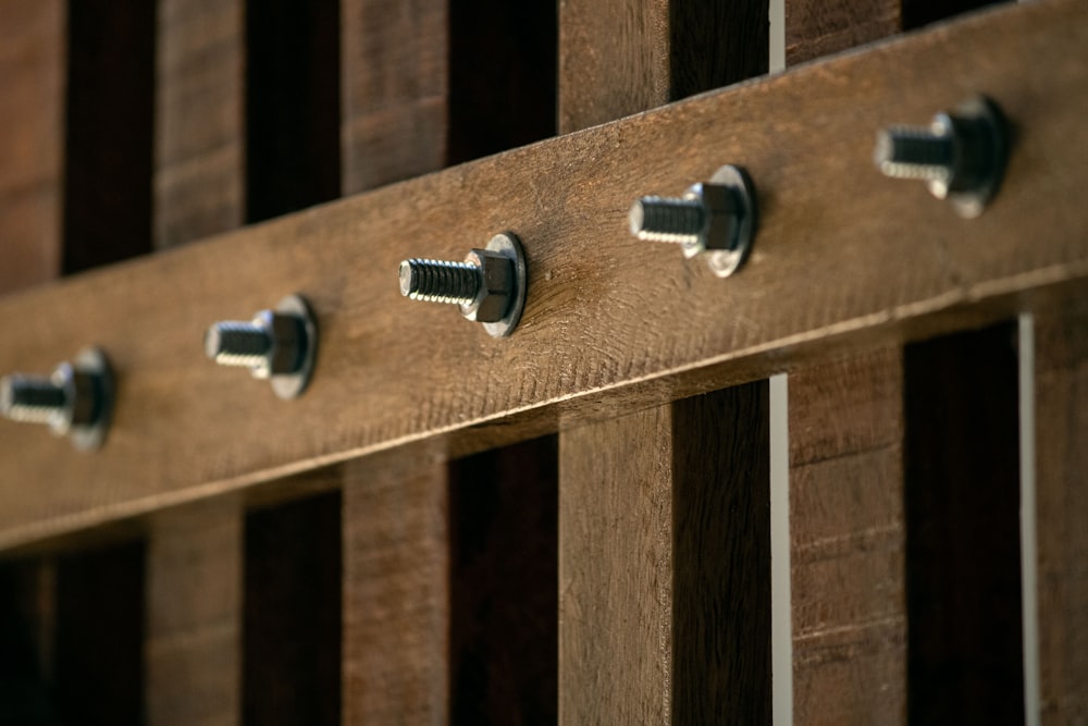 a close up of a wooden fence with screws