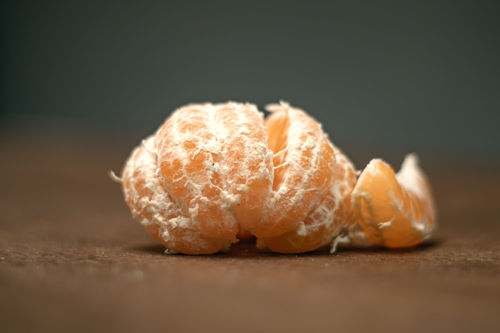 a peeled orange sitting on top of a wooden table