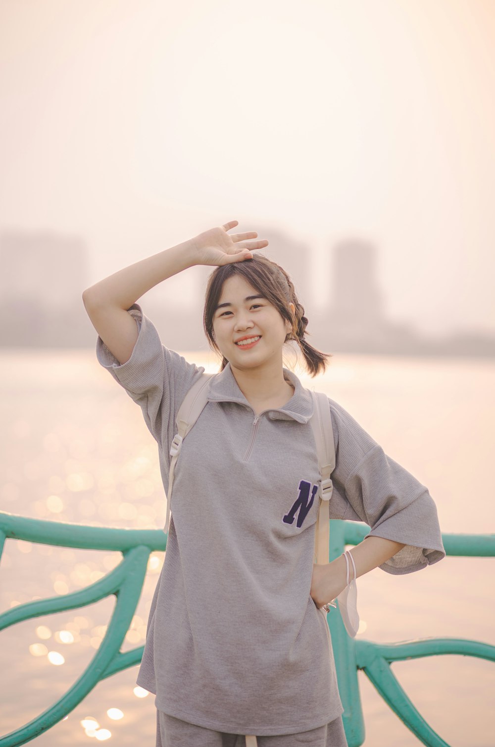 a woman standing next to a body of water