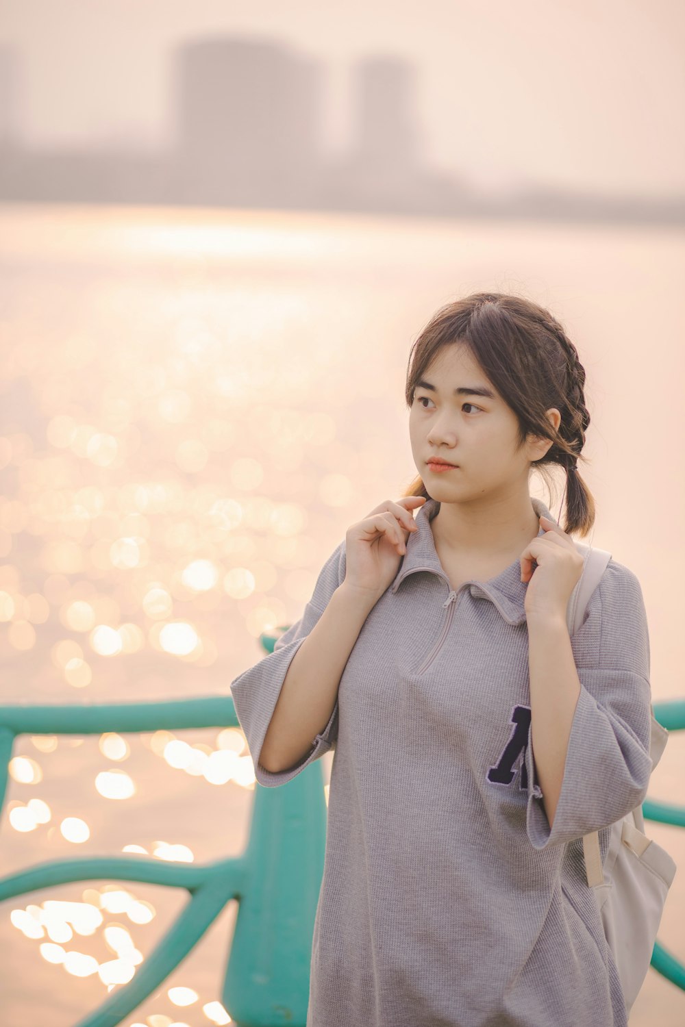 a woman standing next to a body of water