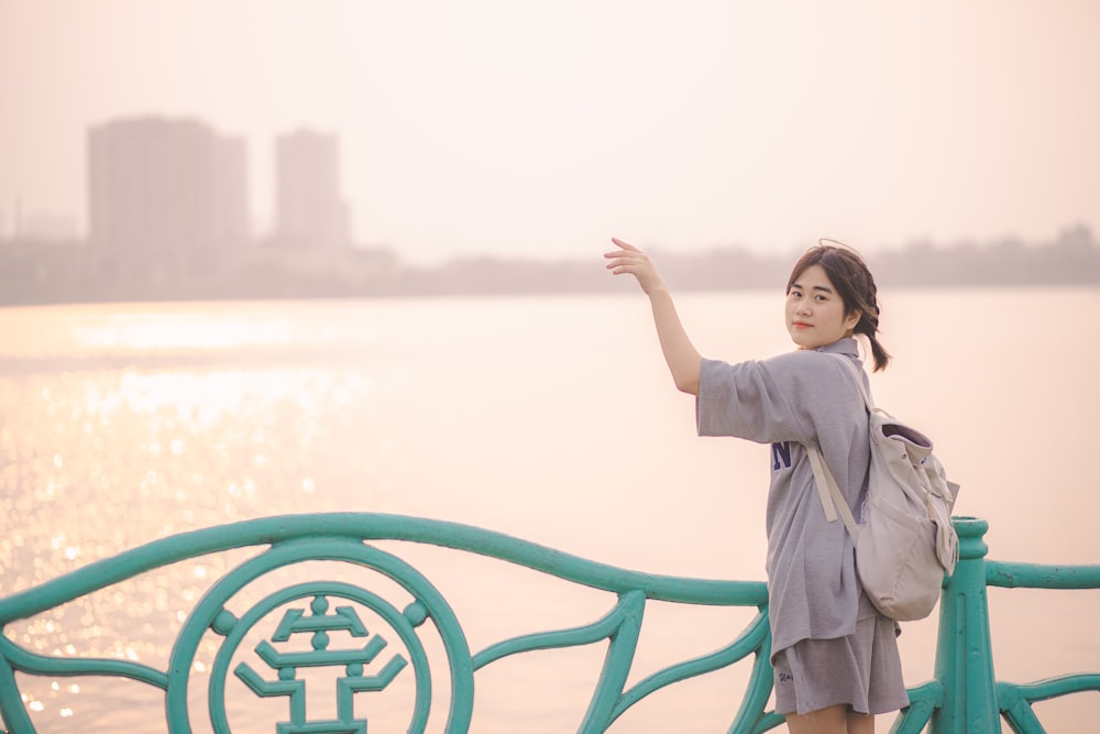 a woman standing next to a body of water