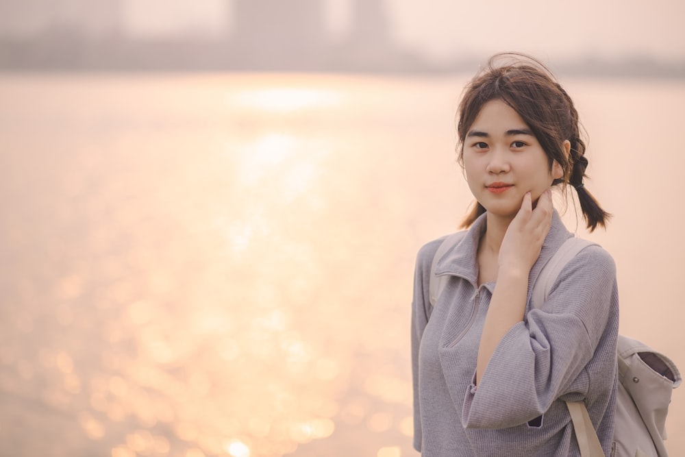 a woman standing next to a body of water