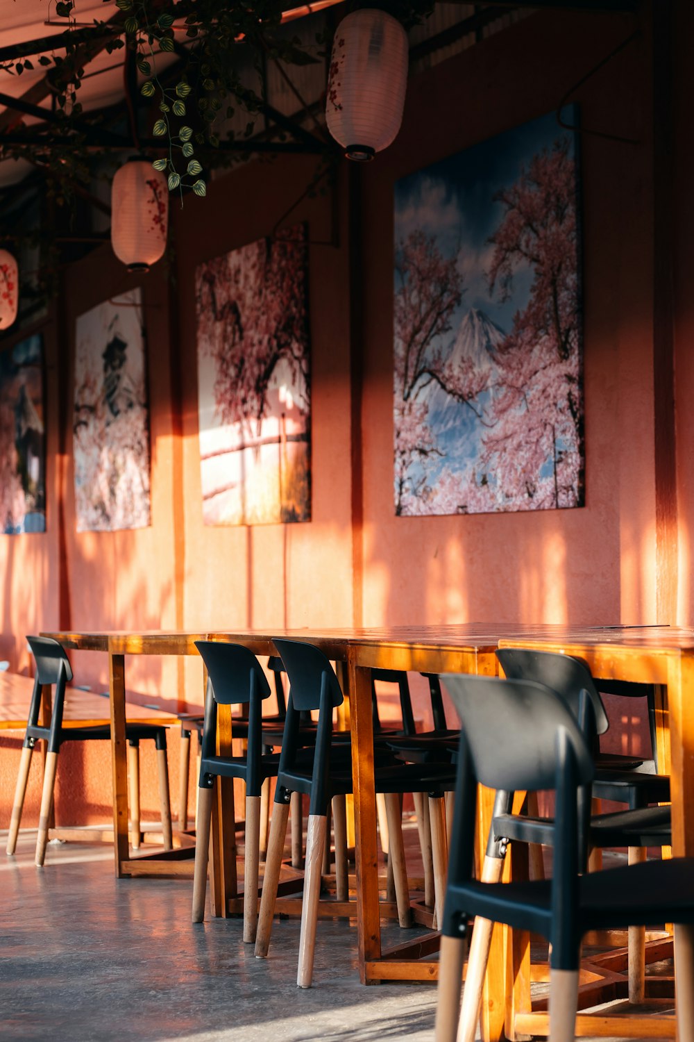 Una mesa larga con sillas y pinturas en la pared