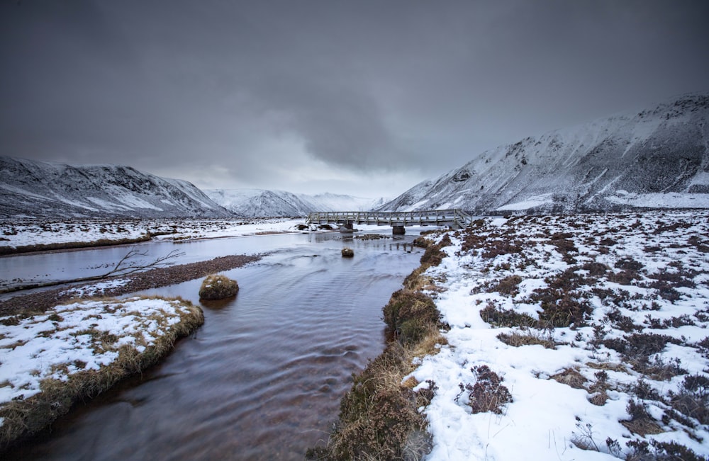 Ein Fluss, der durch ein schneebedecktes Feld fließt