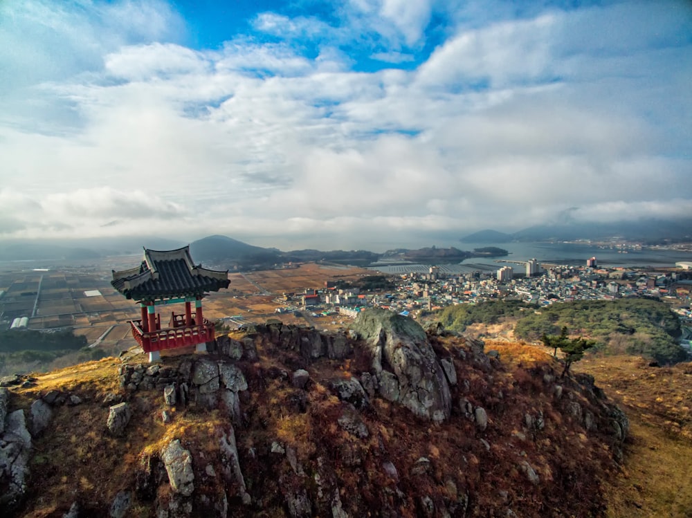 a small pagoda on top of a hill overlooking a city