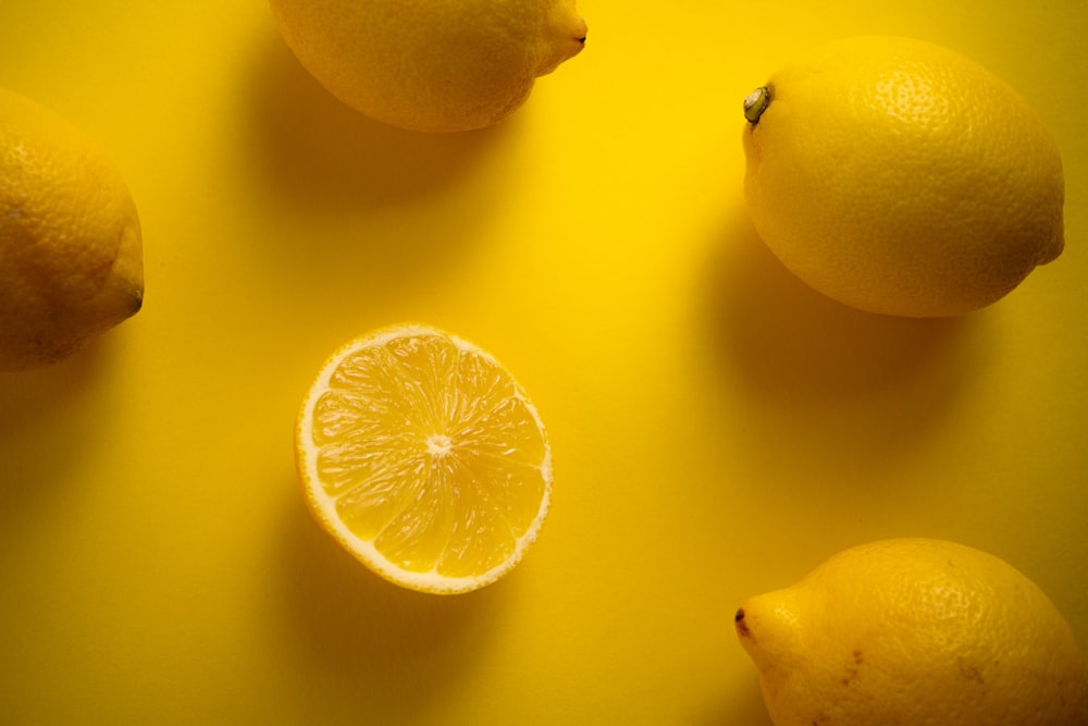 a group of lemons sitting on top of a yellow table