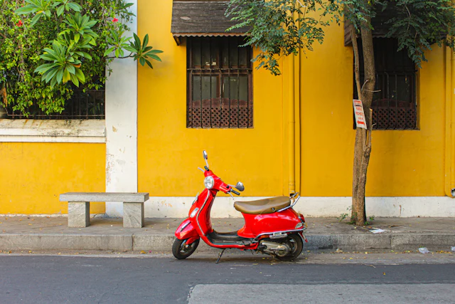 A red scooter parked beside a yellow colonial building, Pondicherry