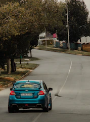Student behind the wheel navigating a quiet suburban street.
