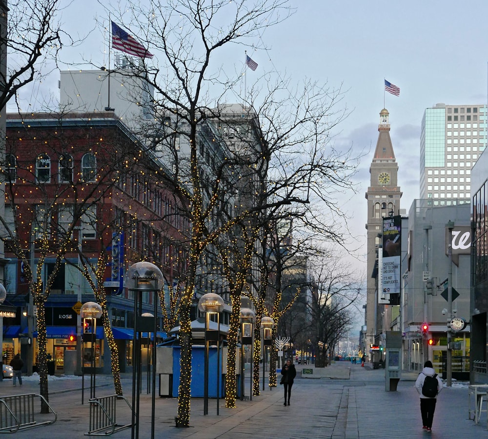 a person walking down a street next to tall buildings