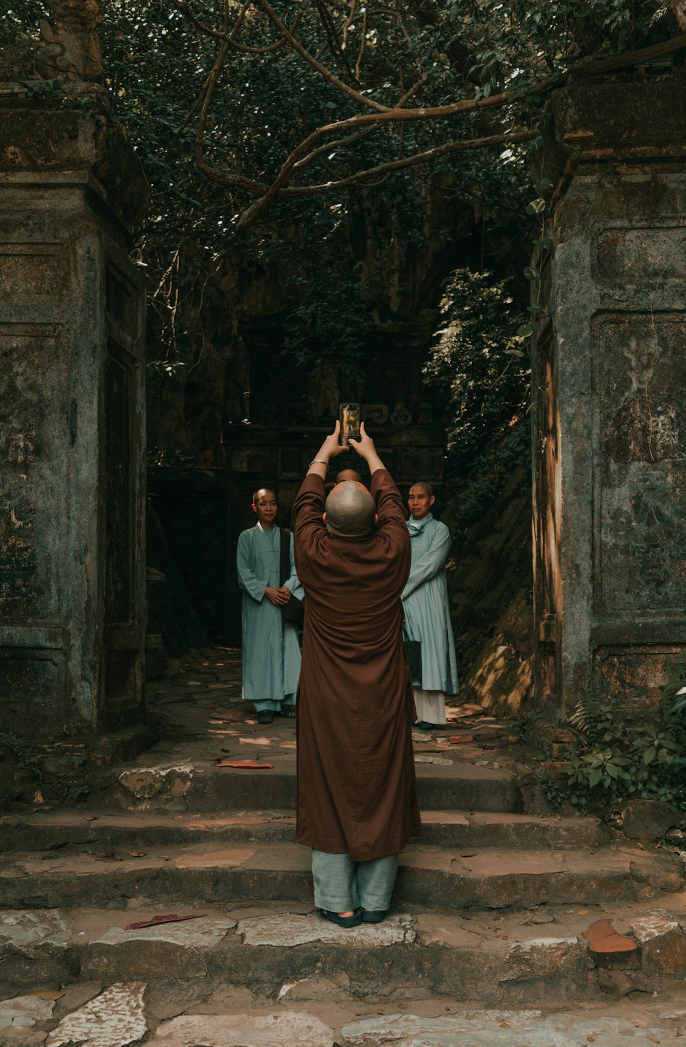 a man taking a picture of a group of monks