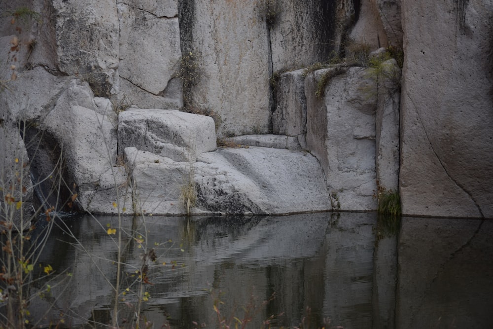 a large rock formation next to a body of water