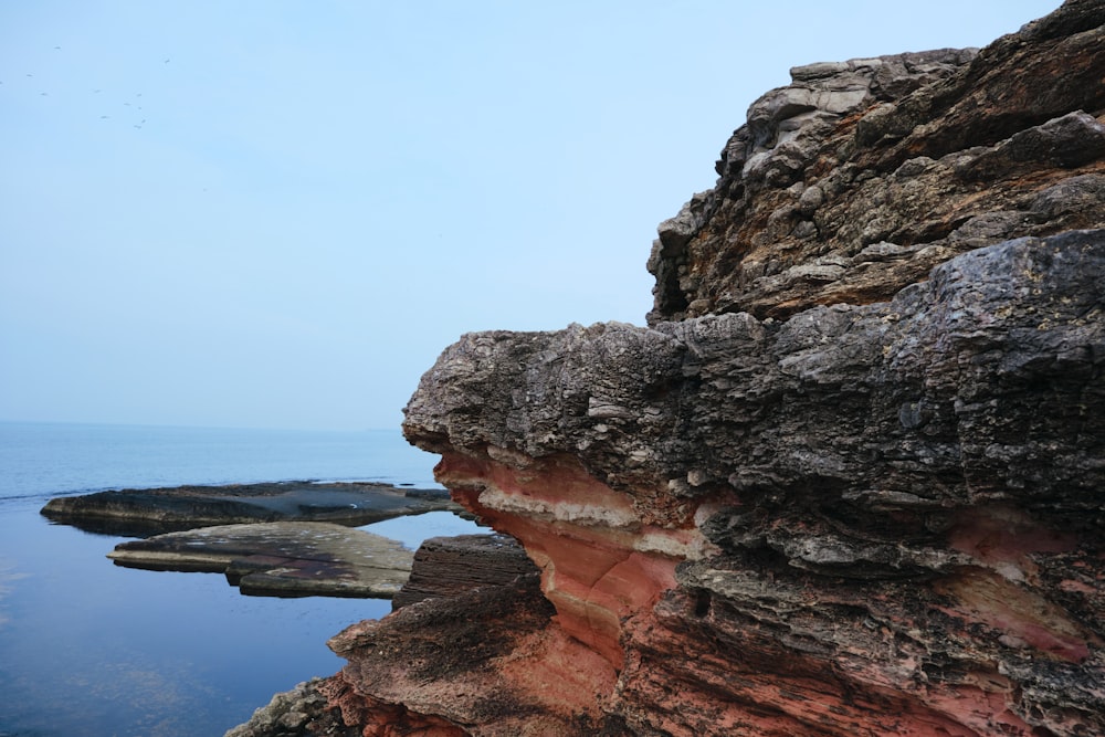 a rock formation on the edge of a body of water