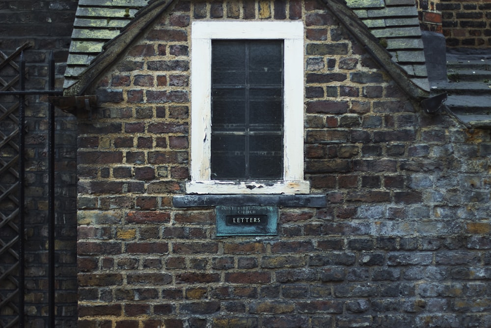 a brick building with a window and a sign on it