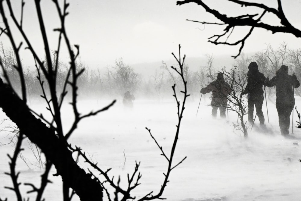 a group of people walking across a snow covered field