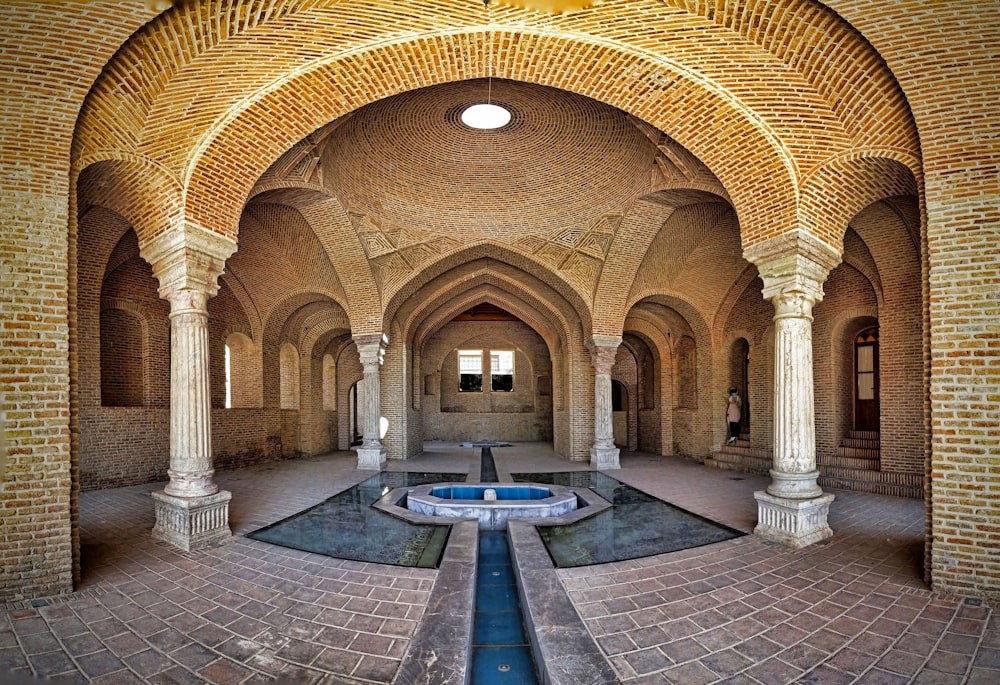 ein großes Gebäude mit einem Brunnen im Inneren