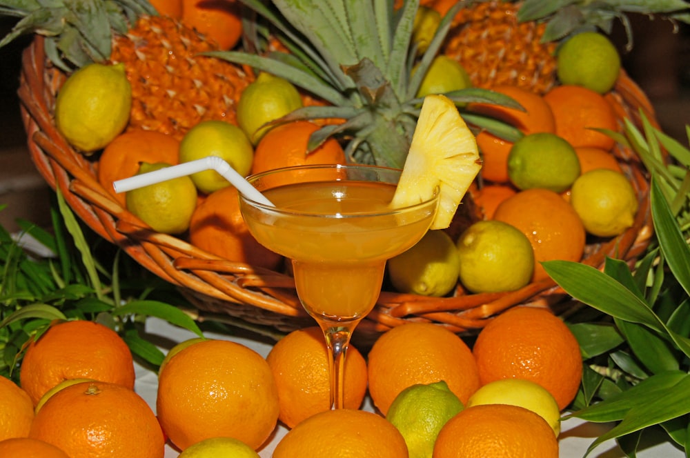 ein Tisch mit Orangen und Ananas neben einer Obstschale