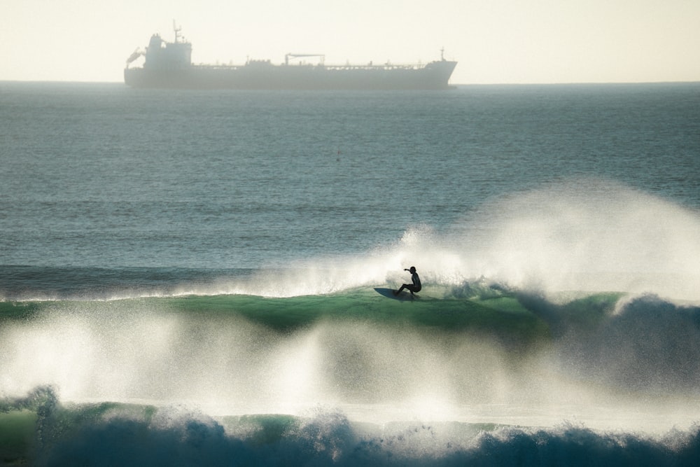 a man riding a wave on top of a surfboard