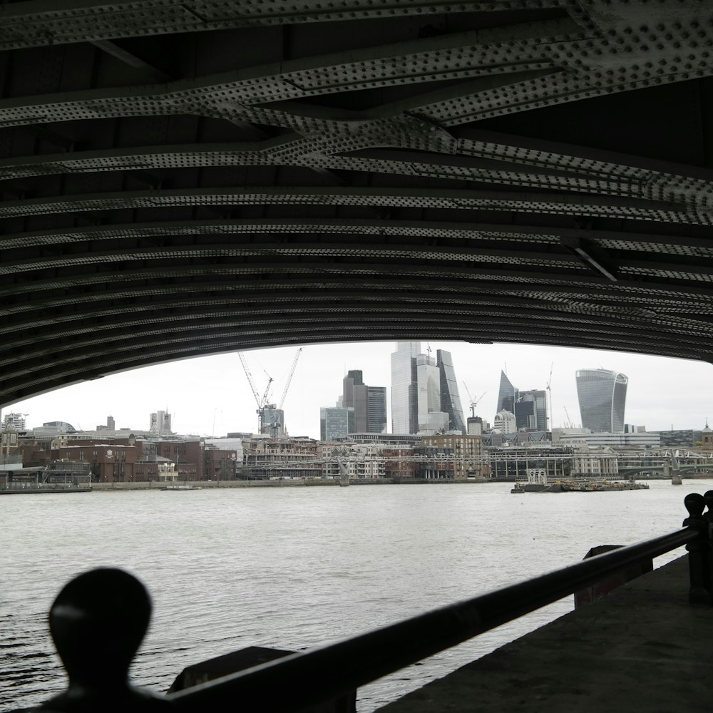 a view of the london skyline from under a bridge