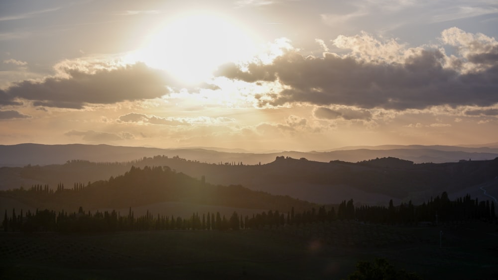 the sun is setting over a mountain range