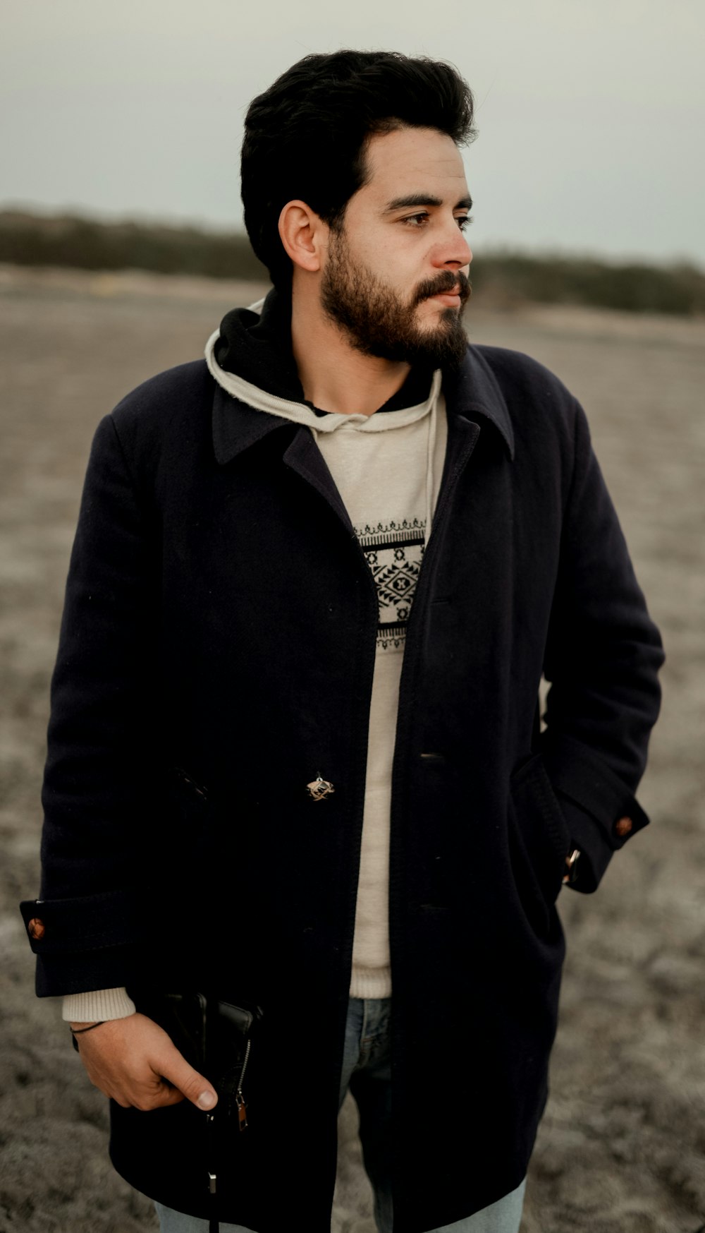 a man with a goatee and a beard standing in a field