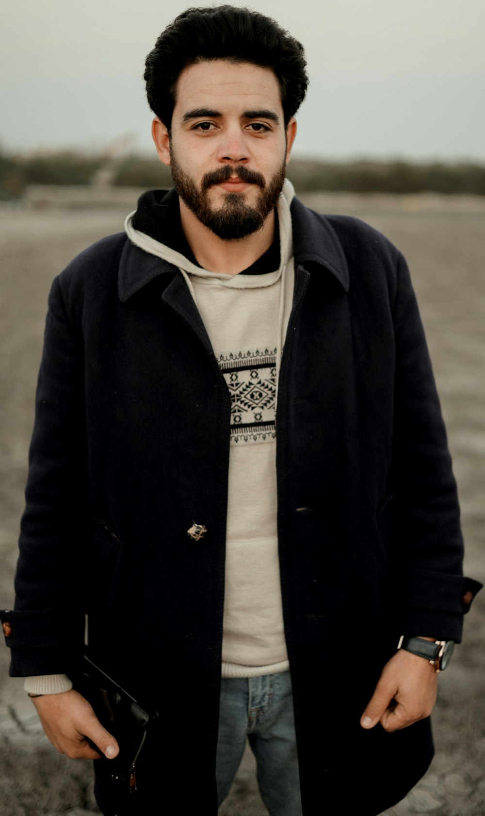 a man with a beard standing in a field