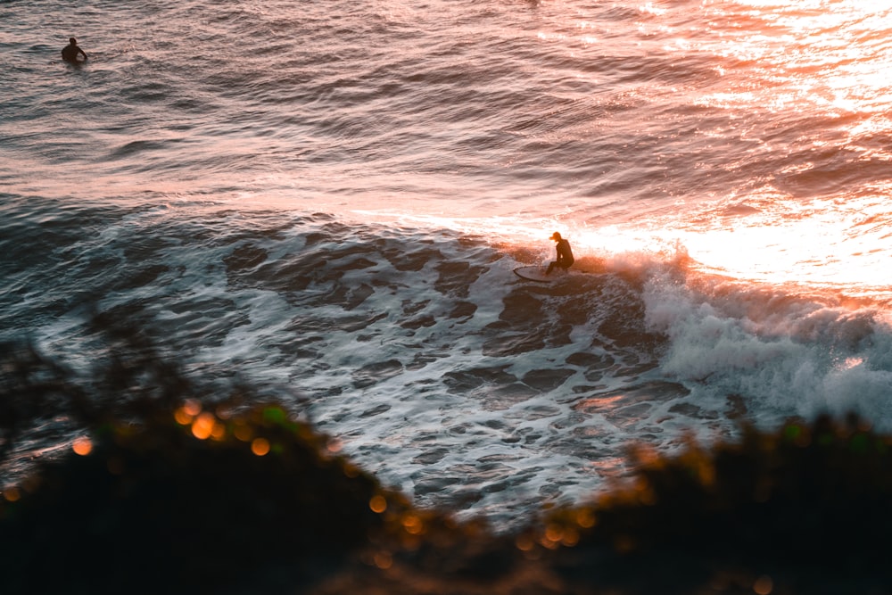 a man riding a wave on top of a surfboard