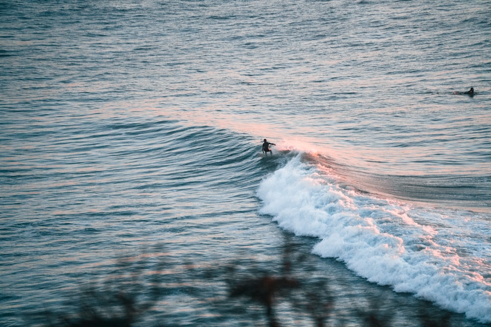 a person riding a wave on top of a surfboard