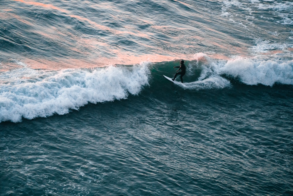 a person riding a surfboard on a wave in the ocean