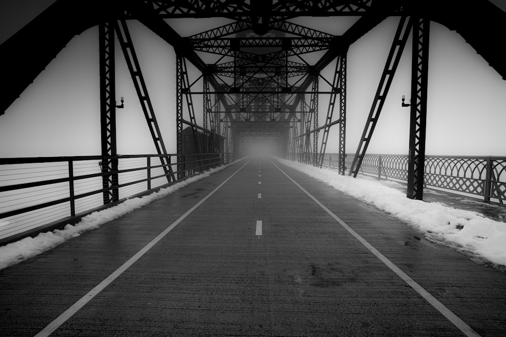 a black and white photo of a bridge in the snow