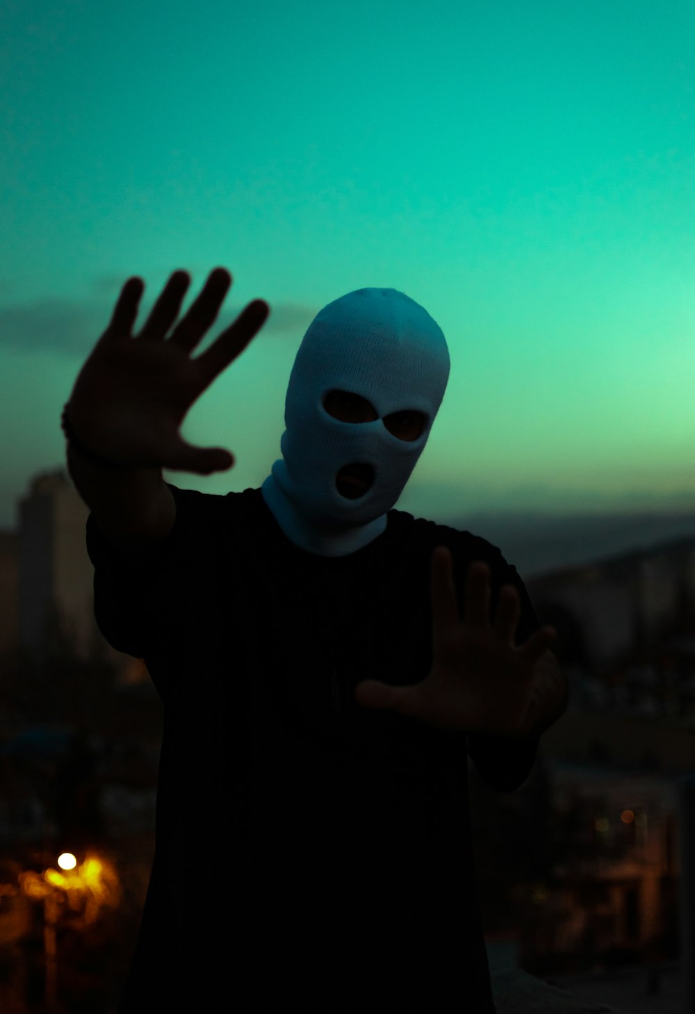 a person wearing a mask and holding their hands up