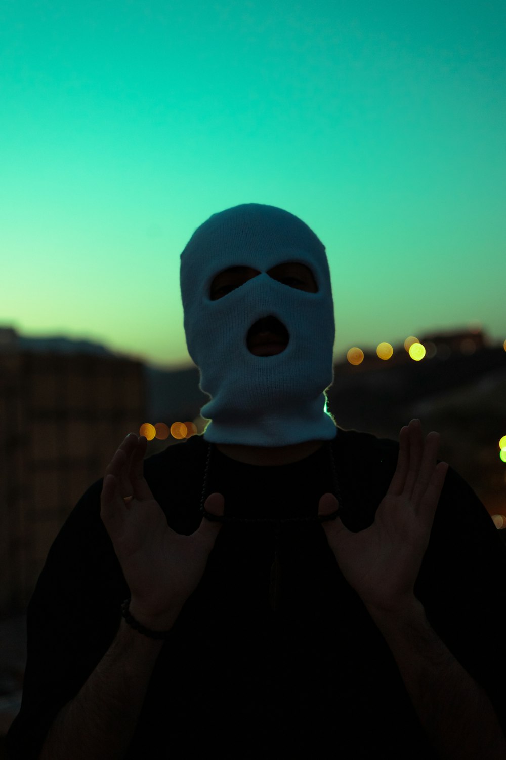 a person wearing a mask with their hands in the air