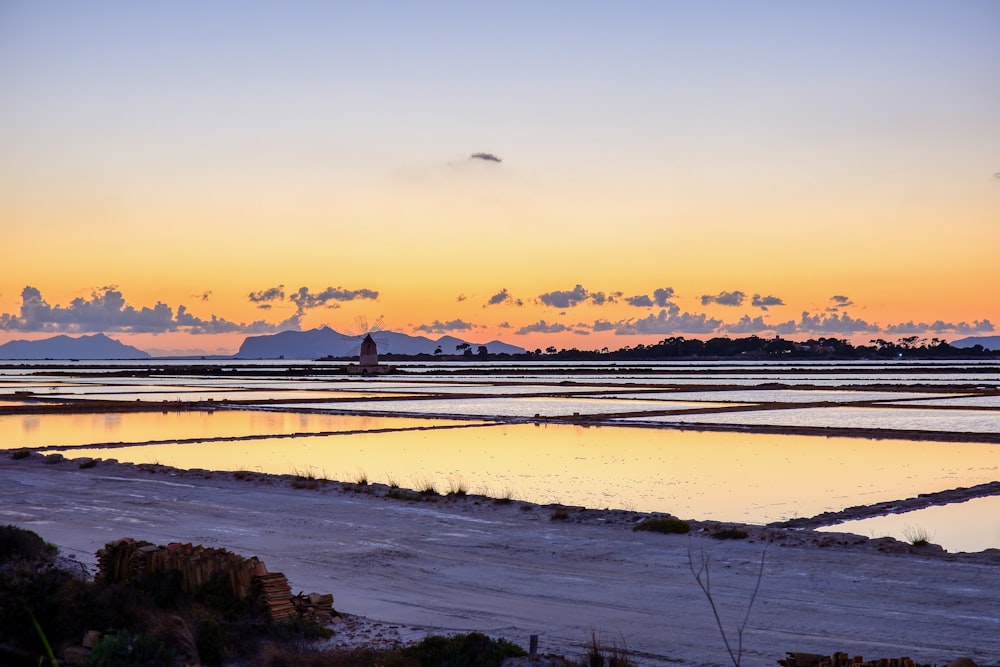 a large body of water with a sky in the background