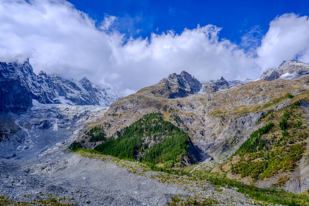 the mountains are covered in snow and green vegetation