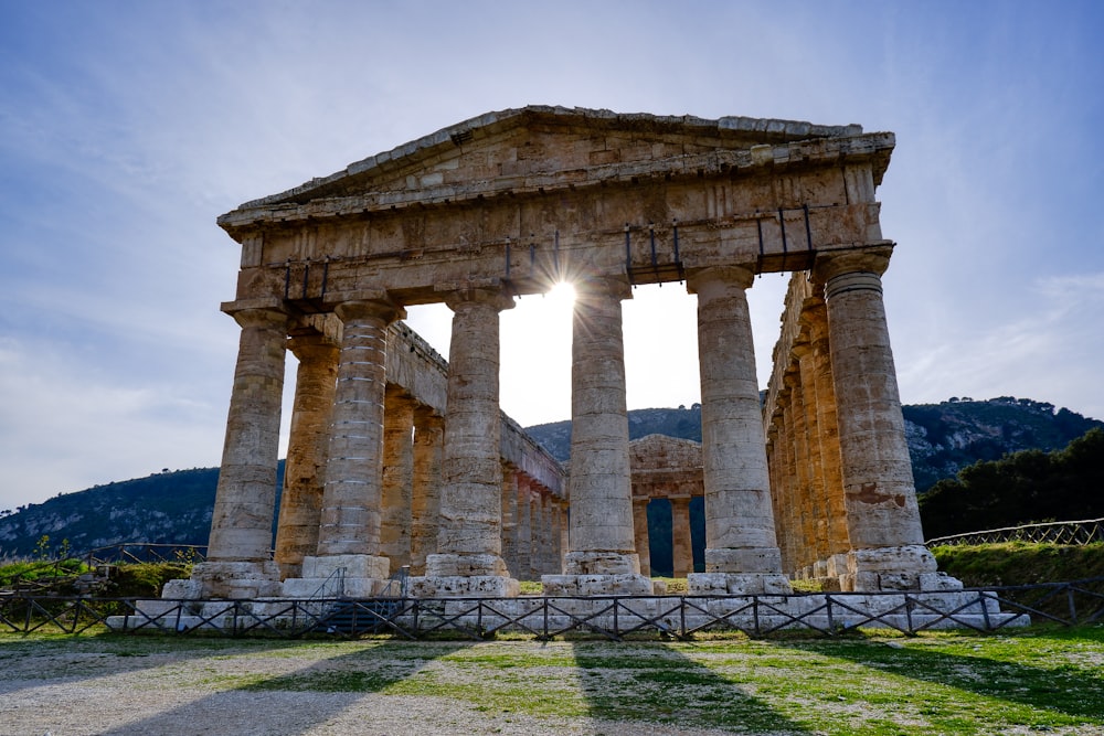 Le soleil brille derrière les ruines d’un temple