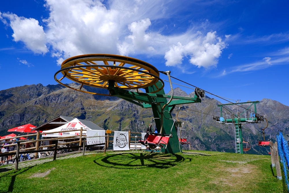 a chair lift sitting on top of a lush green hillside